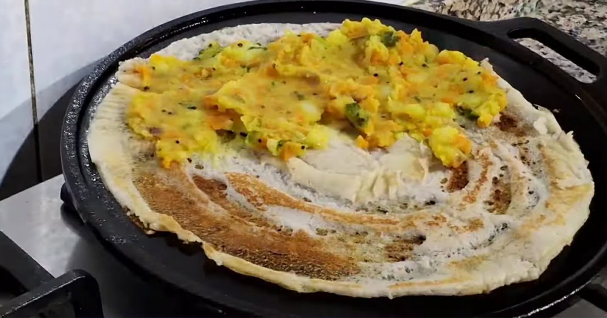 A plate of crispy Masala Dosa filled with spiced potato filling, garnished with coriander leaves, served with chutney